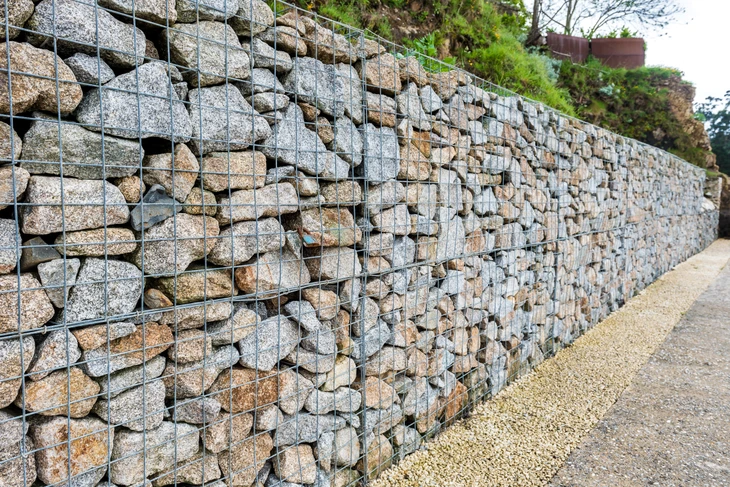 Mur en pierre naturelle avec joints de mortier blanc, construction traditionnelle en moellons calcaires de tailles irrégulières