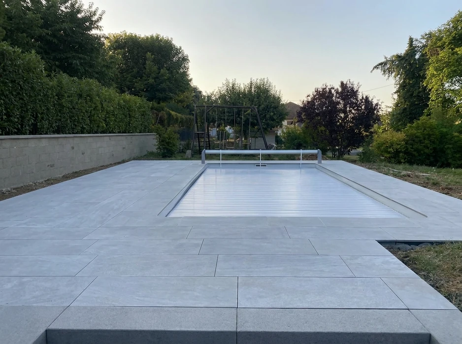 Piscine rectangulaire extérieure entièrement couverte d'un volet roulant automatique à lames en aluminium, type volet immergé hors-sol